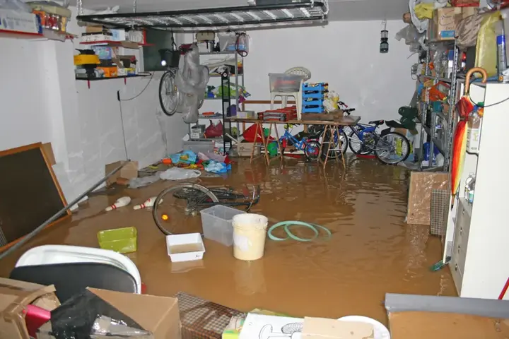 Standing water across a cluttered basement storage room